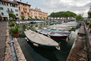 代森扎諾－德爾加達的住宿－Suite "Castello" del Garda - APT per coppie Garda，一群船停靠在运河上,有建筑物