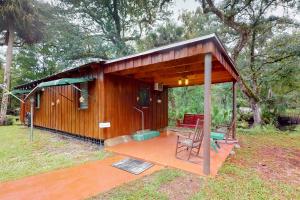 a small wooden cabin with a bench on a deck at Waccasassa Wonder in Morriston