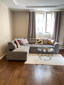 a living room with a couch and a table at Bel appartement proche de Paris in Colombes