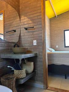 a bathroom with a sink and a bed in a room at Casa ecológica Toca do Barreiro in Coronel José Diaz