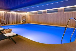 a swimming pool in a hotel room with a blue lighting at Hotel Residence Europe & Spa in Clichy