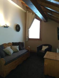 a living room with a couch and a window at Duplex résidence spa Mont-Blanc in Vallorcine