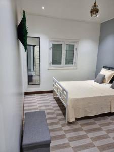 1 dormitorio con 1 cama grande y 2 ventanas en Villa Rozeen, en Yaoundé