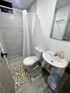 ein Badezimmer mit einem weißen WC und einem Waschbecken in der Unterkunft Nuevo Apartamento frente al Centro Comercial VIVA in Tunja