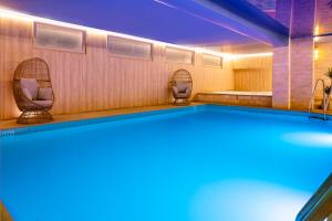 a swimming pool with two chairs and a tub at Hotel Residence Europe & Spa in Clichy