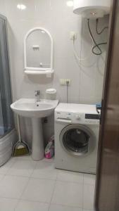 ein Badezimmer mit einer Waschmaschine und einem Waschbecken in der Unterkunft Кобаладзе 2 in Batumi