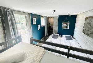 Chalet le petit Nicolas, jacuzzi, vue Mont Blanc في شامونيه مون بلان: سريرين في غرفة بجدران زرقاء