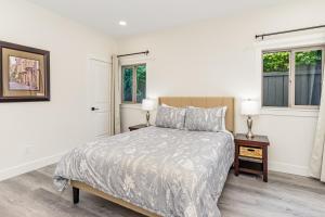a white bedroom with a bed and two windows at Woodland Park Villa in Seattle