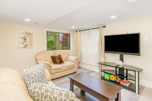 een woonkamer met een bank en een tv bij Woodland Park Villa in Seattle