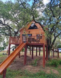 un parque infantil de madera con una casa en el árbol en Haasienda - Nido del Colibri - Casa de Arbol, 