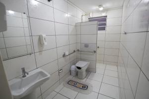 a white bathroom with a sink and a toilet at City Hotel, Curitiba in Curitiba