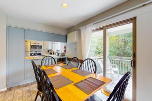 a dining room with a table and chairs and a balcony at Smugglers' Notch Resort Slopeside 39 in Jeffersonville