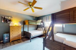 a bedroom with two bunk beds and a ceiling fan at Smugglers' Notch Resort Slopeside 39 in Jeffersonville