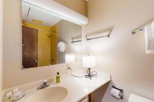 un bagno con lavandino e specchio di Smugglers' Notch Resort Slopeside 39 a Jeffersonville Altre 11 foto