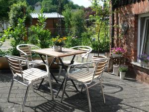 a wooden table and chairs on a patio at 4 Bett Ferienwohnung Lavendel in Wengenroth