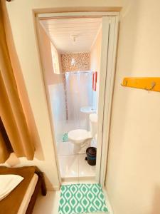 a small bathroom with a toilet and a shower at Pousada Flor do Sol in Aparecida