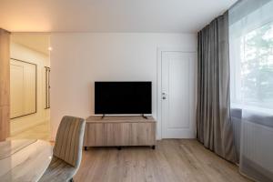 a living room with a flat screen tv on a cabinet at Modern 2 bedroom Vytenio apartment in city centre I Self check-in in Vilnius