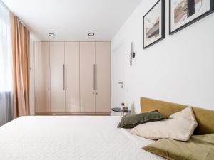 a bedroom with a white bed and a cabinet at Modern 2 bedroom Vytenio apartment in city centre I Self check-in in Vilnius