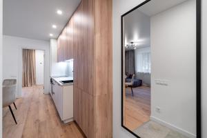 a kitchen and a living room with a mirror at Modern 2 bedroom Vytenio apartment in city centre I Self check-in in Vilnius
