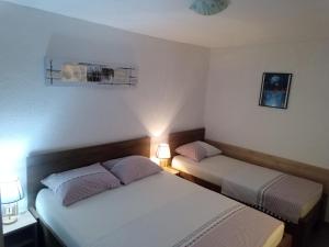 - 2 lits dans une petite chambre avec 2 lampes dans l'établissement Apartment Feral, à Neum