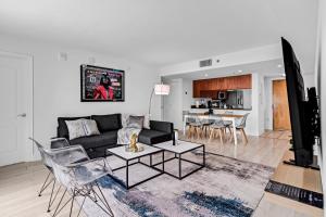 un soggiorno con divano nero e TV di LUX 2B/2B Brickell - Free Parking a Miami