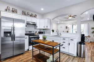 uma cozinha com armários brancos e um frigorífico de aço inoxidável em At Ease em San Antonio