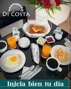 una mesa cubierta con productos para el desayuno y zumo de naranja en Di Costa Hotel, en Piura