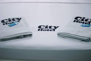 a couple of towels sitting on top of a bed at City Hotel, Curitiba in Curitiba