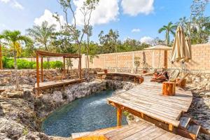 a bridge over a river with a table and an umbrella at RELAX TULUM Family Friendly Apartment in the in the jungle - pools & cenotes in Tulum +165 photos