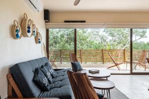 a living room with a couch and a table at RELAX TULUM Family Friendly Apartment in the in the jungle - pools & cenotes in Tulum