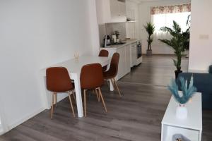 a kitchen and living room with a white table and chairs at Sandnes Central Suite in Sandnes
