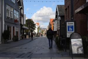 a person walking down a street in a town at Sandnes Central Suite in Sandnes