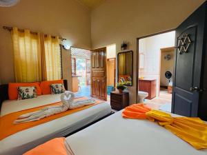 a bedroom with two beds with orange and yellow at Villas Allen Puerto Viejo in Puerto Viejo