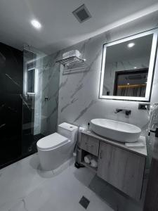 a bathroom with a sink and a toilet and a mirror at Hotel Vip La Guaira in Macuto