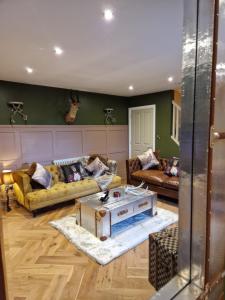 ein Wohnzimmer mit Sofas und einem Couchtisch in der Unterkunft The Hamilton luxury holiday let's- The Coach House with hot tub in Scorton