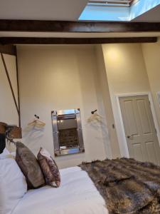 a bedroom with a bed and a mirror on the wall at The Hamilton luxury holiday let's- The Coach House with hot tub in Scorton