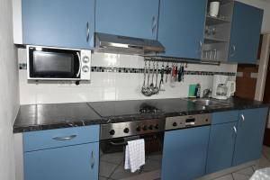 eine blaue Küche mit einer Spüle und einer Mikrowelle in der Unterkunft Areit Living corner top 21 in Zell am See