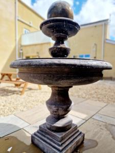 a stone fountain sitting on top of a sidewalk at The Hamilton luxury holiday let's- The Coach House with hot tub in Scorton