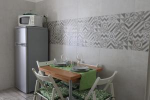 a kitchen with a table with chairs and a refrigerator at Pietro's house in Rome