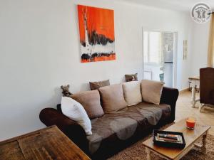 un salon avec un canapé marron et une table dans l'établissement Gîte calme avec jardin clôturé, animaux acceptés, parking et WIFI à Viels-Maisons - FR-1-532-21, à Viels-Maisons