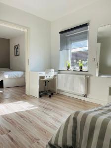 a bedroom with a bed and a desk and a window at Ferienwohnung DeuxPonts II in Rimschweiler