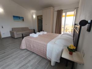 - une chambre avec un lit, un canapé et une fenêtre dans l'établissement Costa di Sopra Affittacamere, à Quartu SantʼElena