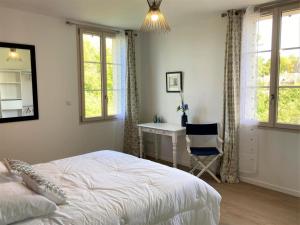 a bedroom with a bed and a desk and windows at Maison de village charmante avec jardin et terrasse, proche de Soissons, idéale familles et animaux acceptés - FR-1-532-19 in Buzancy