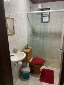 uma casa de banho com um chuveiro, um WC e um lavatório. em Pousada Sol e Mar na Ilha do Mel