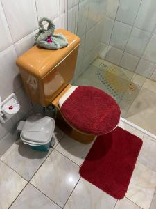 een badkamer met een toilet en 2 rode handdoeken bij Pousada Sol e Mar in Ilha do Mel