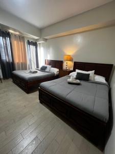 una camera d'albergo con due letti e una lampada di Large studio Cubao with 2 beds a Manila
