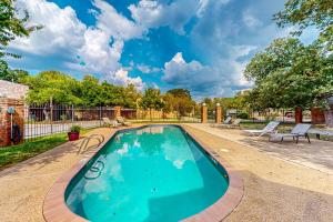 a swimming pool in a yard with two chairs at Traditions in College Station