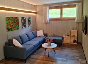 uma sala de estar com um sofá azul e uma mesa em Chesa Bunita Trais em Gaschurn