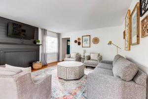 a living room with two couches and a table at Deacon Stays: The Polo - Walk to WFU in Winston-Salem