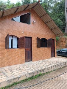 a brick building with two doors and a window at Pesque pague pousada do Carlinho in Pinheiral